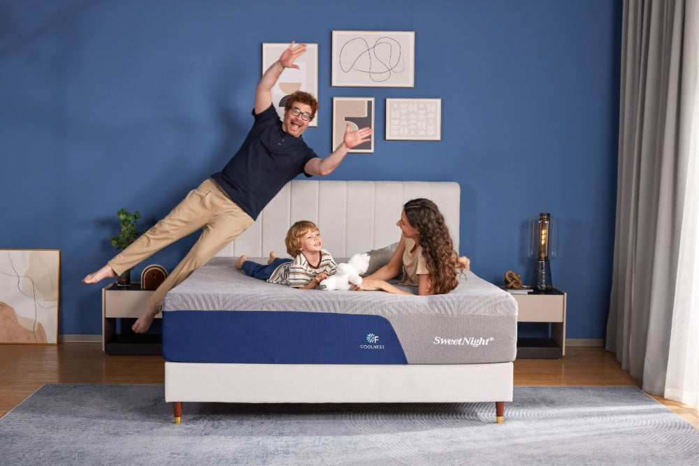 Happy family playing on a spacious Sweetnight mattress, illustrating the perfect Christmas gift for parents and children.