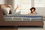 A woman lies on a checkered mattress with a cutaway view revealing its multi-layer foam construction for optimal support and breathability.