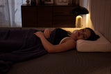 Woman sleeping comfortably on twelve inch memory foam mattress showing ideal thickness for average weight side sleepers