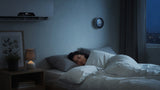 Peaceful sleeper in a cool bedroom with an air conditioner set to an ideal sleep temperature