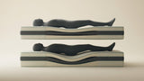 Bare queen mattress in a minimalist bedroom with a visible sagging dip through the middle where a heavier sleeper's hips rest.