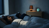 Light sleeper lying awake at 3 a.m. in a dark bedroom while her partner sleeps soundly beside her